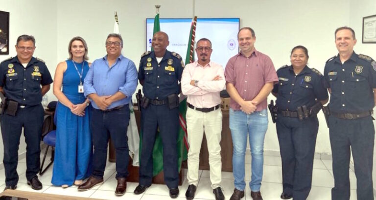 Fotografia mostra 8 pessoas lado a lado, entre elas: Inspetor Carlos Celso, prefeito Maurício Aparecido da Silva (Índio), vereador Fabrício Martelozzi e secretário Alessandro Mansano, que participaram de reunião sobre a criação da Guarda Municipal de Mandaguaçu.